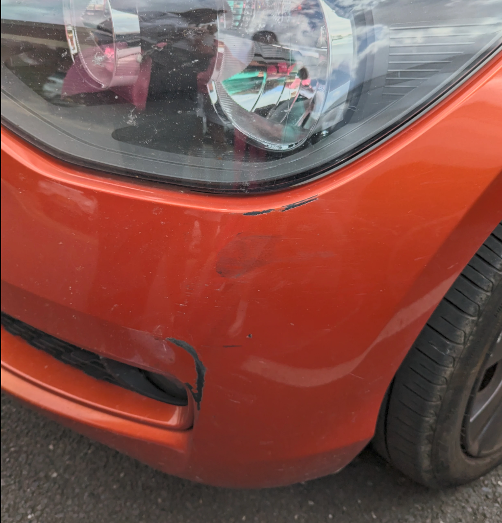 Orange bumper scuff before repair
